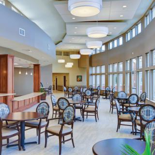 A modern dining area with elegant furniture and large windows.