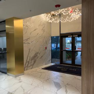 A stylish modern lobby featuring marble walls, contemporary lighting, and a welcoming entrance.