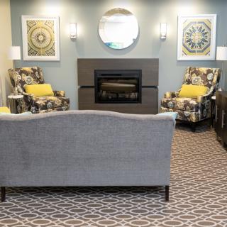 A cozy living room featuring a central fireplace, comfortable seating, and stylish decor.
