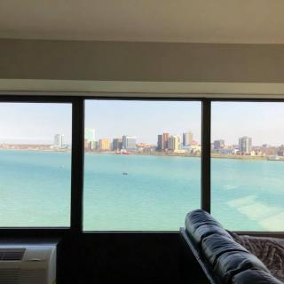 A stunning city skyline view from inside an apartment, overlooking a large body of water.