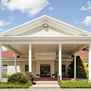 A grand entrance with white columns on a sunny day.