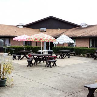 A cozy outdoor seating area featuring tables with umbrellas, perfect for a relaxing meal.