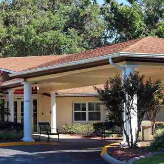 A residential building with a covered entrance and landscaped surroundings.