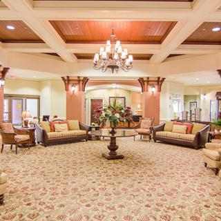 An elegant hotel lobby featuring comfortable seating and a grand chandelier.