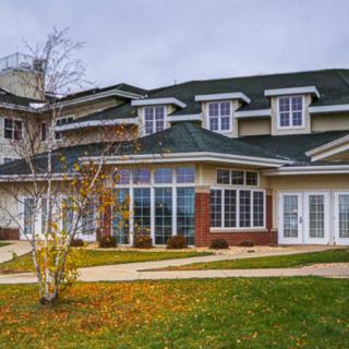 A large modern house with multiple windows and a well-maintained lawn.