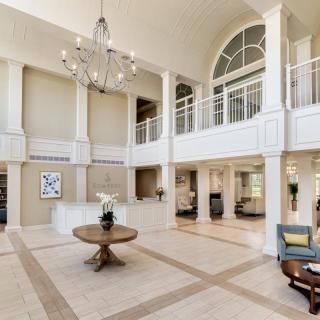 Spacious lobby with elegant chandelier and stylish decor.