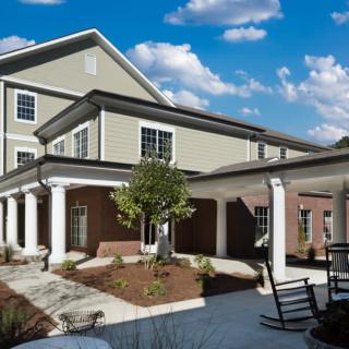 A modern residential building with a landscaped courtyard and outdoor seating area.