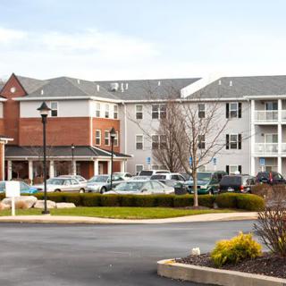 A suburban residential building with a parking lot in front.