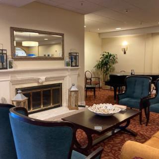 A cozy lounge area featuring comfortable seating, a fireplace, and a piano.