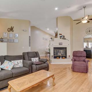 A cozy living room featuring comfortable seating, a central fireplace, and wooden flooring.