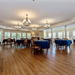 Spacious dining area with elegant chandeliers and large windows.