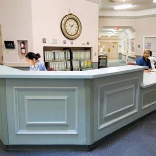A reception area in a hospital with staff members working at the desk.