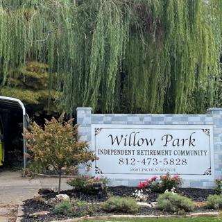 Entrance sign to Willow Park surrounded by greenery and landscaping.