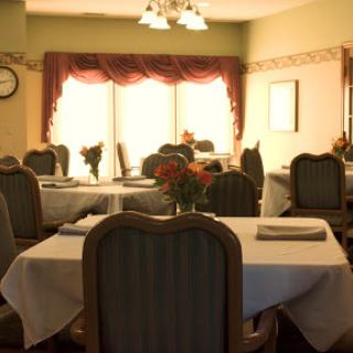 A cozy dining area featuring elegantly set tables and soft lighting.