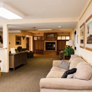 A cozy living room with a beige sofa, television, and decorative elements.