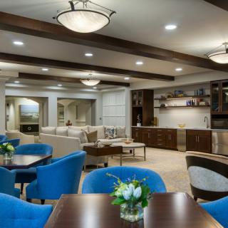 A modern living room with blue chairs and wood accents.