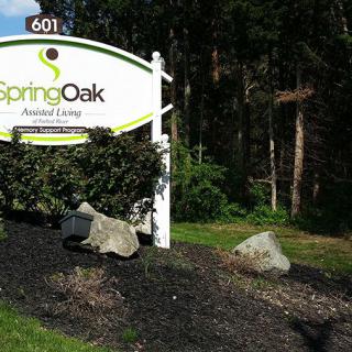 Sign for Spring Oak Assisted Living surrounded by trees.