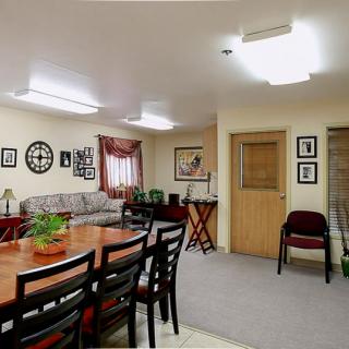 A well-lit meeting room with a large conference table and chairs, featuring cozy decor.
