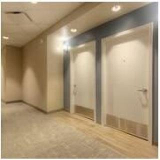 A well-lit hallway with two closed doors.