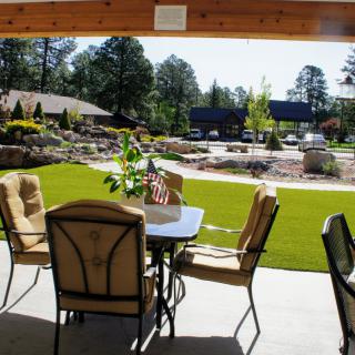 A scenic outdoor patio with comfortable seating overlooking a landscaped garden.
