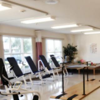 A rehabilitation center equipped with exercise benches and therapy parallel bars.