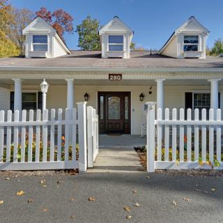 A charming suburban house with a white picket fence and a welcoming porch.