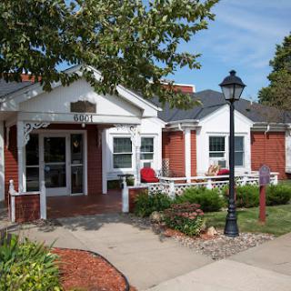 A charming residential building surrounded by well-maintained landscaping.
