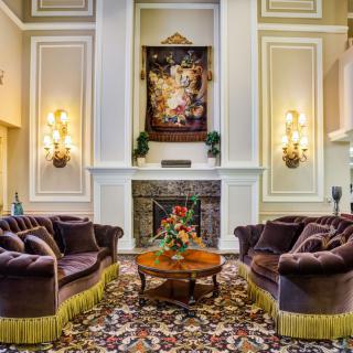 A luxurious living room with elegant sofas and a fireplace, adorned with sophisticated decor.