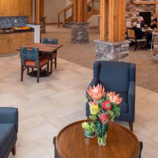 A cozy hotel lobby with elegant furniture and a bouquet of flowers on the table.