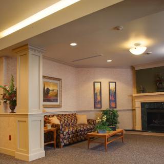 A cozy lobby area featuring a comfortable couch, decorative plants, and a fireplace.