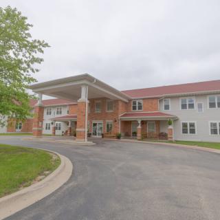 A two-story brick and siding building with a covered entrance and surrounding driveway.