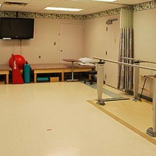 A physical therapy room equipped with parallel bars and exercise equipment.
