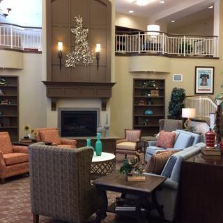 A cozy living room with comfortable seating, a fireplace, and bookshelves.