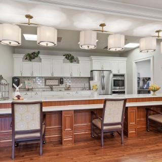 A modern kitchen interior with a long counter, elegant lighting, and stylish appliances.