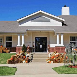 A suburban house decorated for fall with pumpkins and autumn-themed accents.