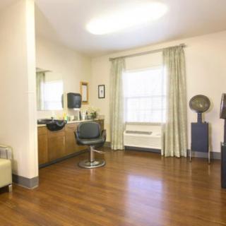 A modern hair salon with a styling station and barber chair.