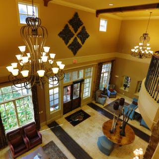An elegant lobby featuring a grand chandelier, comfortable seating, and stylish decor.