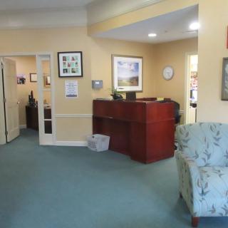 A reception area in an office, featuring a wooden desk and comfortable seating.