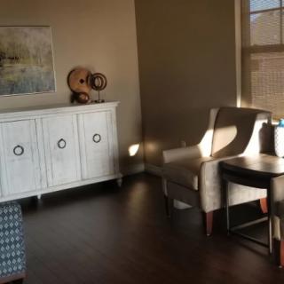A cozy living room with tasteful decor and furniture, illuminated by natural light.