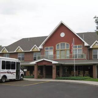 A commercial building with a parked bus in front of its entrance.
