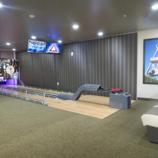 An indoor mini-golf area within an arcade setting, featuring a course with vibrant lighting and a relaxing atmosphere.
