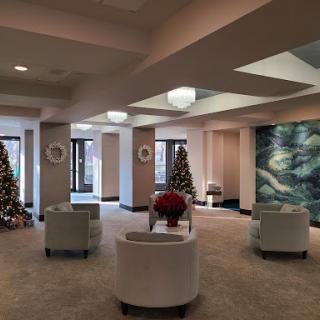 A beautifully decorated lobby featuring Christmas trees and a modern seating area.
