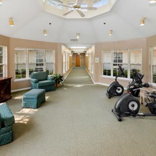 A modern indoor gym area featuring stationary bikes and comfortable seating.