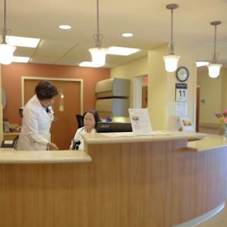 A reception area in a medical clinic where staff assist patients.