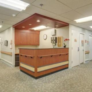 A clean and organized hospital reception area with a wooden desk and neutral color scheme.