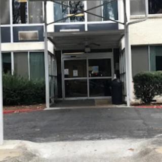 Entrance to a building with glass doors and an overhang.