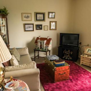 A cozy living room with a sofa, television, and decorated walls.