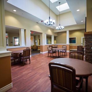 A spacious interior with tables, chairs, skylights, and chandeliers.