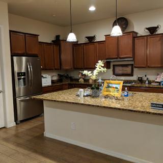 A modern kitchen featuring wooden cabinets, granite countertops, and contemporary appliances.