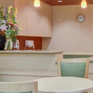 A cozy reception area with a small table, chairs, and decorative flowers on the counter.